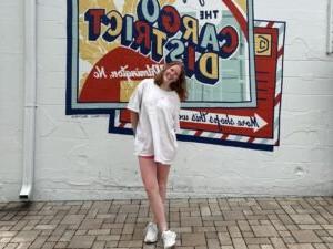 Mandy Jo stands in front of a mural painted on a walk in Wilmington, NC.